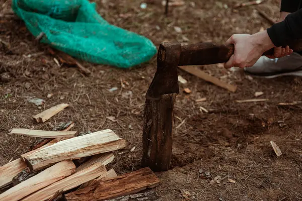 斧で火を消すために木を切る 木を切る斧を持った大邸宅の手 バーベキューの準備 ファイアウッドを作る ランバージャック 高品質の写真 ロイヤリティフリーのストック画像