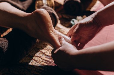 Tai ayak masajını yağlı, mum ışığıyla aydınlatılan sakin bir spa ortamında çekiyoruz. Yüksek kalite fotoğraf