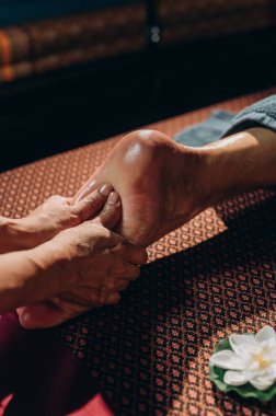Tai ayak masajını yağlı, mum ışığıyla aydınlatılan sakin bir spa ortamında çekiyoruz. Yüksek kalite fotoğraf