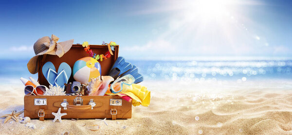 Summer Beach Preparation - Suitcase And Accessories With Sand And Defocused Glittering On Sea - Travel and Departure Concepts