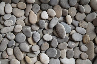 Stonework, with a yellow interlayer, of rolled smooth pebbles, creates an aesthetic mood of a row built in a special order, photographed in a studio with artificial lighting.