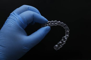 Diş uzmanları tarafından dişleri düzenlemek için kullanılan düzgün hizalayıcılarla ortodontik tedavi. Dişlerin düzgün hizalı tepsilerle yenilenmesi. Ortodonti uzmanlığı.