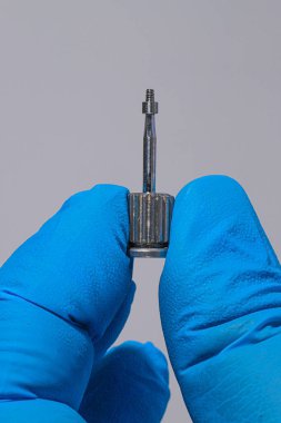 Mavi eldiven takan bir dişçinin tam kemerli diş protezi. İmplant destekli porselen, tam kemerli diş protezi. Vidalı implant diş protezi. Gülümse tasarımı.