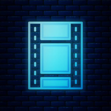 Parlayan neon oyun video simgesi tuğla duvar arka planında izole edildi. Film şeridi tabelası. Vektör.