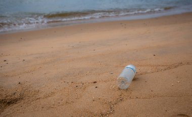 Plastik şişe atıkları sahilde insan kaynaklı kötü çevre, Tayland sahillerinde kirli kum ve deniz.