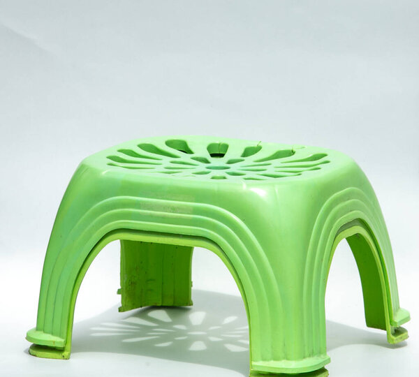 Зеленый пластиковый стул на белом фоне