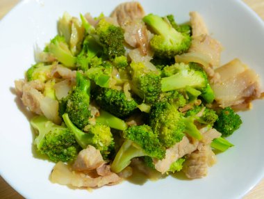 Domuz etli kızarmış sebzeler, beyaz tabakta Tayland yemeği ile karıştırılmış brokoli..