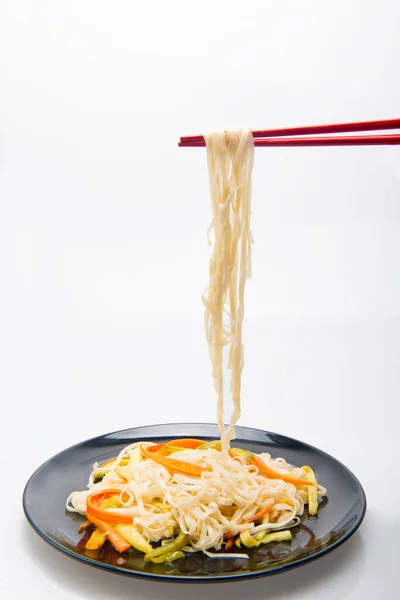 竹のテーブルクロスに野菜と箸が付いた麺 — ストック写真