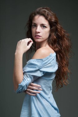 young redhead female model on plain background with copyspace