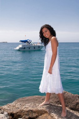 young woman on the beach enjoying the good weather near the sea