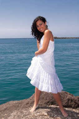 young woman on the beach enjoying the good weather near the sea