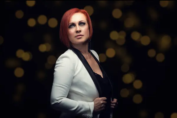 attractive woman in a white suit jacket on dark background and soft lighting as an advertising model