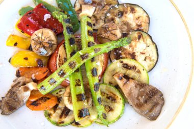 Lezzetli ızgara biftek ve beyaz tabakta sebze.