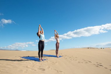 Gün doğumunda plajda yoga yapan bir kadın. sağlıklı yaşam tarzı ve spor.