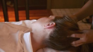 Tanınmayan kızın güzellik kliniğinde ya da lüks kaplıca salonunda yüz ve kafa masajı yaptırıyor. Genç bir kadın masaj salonundan zevk alıyor. Güzellik ve vücut bakımı, sağlık konsepti..