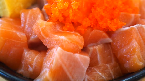 日本料理店では新鮮な魚やキャビアやイクラと一緒にサーモン丼を閉じます 丼物の新鮮な生鮭の切り身 ご飯の上に生の魚をスライス ヘルシーなおいしい食べ物 — ストック動画
