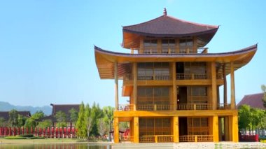Yazın güneşli bir günde yeşil bahçeli ve torii kapılı güzel geleneksel Japon ahşap evi manzarası. Japonya tarzı tapınak veya tematik parkta sergi