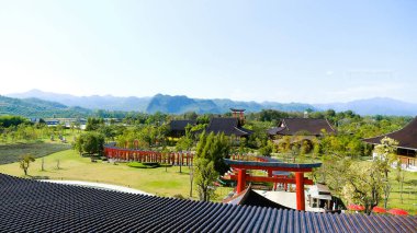 Dağlarla, yeşil tepelerle ve Japon Torii kapılarıyla muhteşem manzarayı seyret. Mükemmel doğa, tematik park Asya tarzında. Seyahat, turizm konsepti.