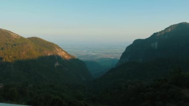 Yeşil tepelerde, yağmur ormanı dağları olan güzel yeşil kanyonda sıcak güneş ışığı. Gün batımında doğal manzara. Doi Phahee, Chiang Rai Tayland 'da..