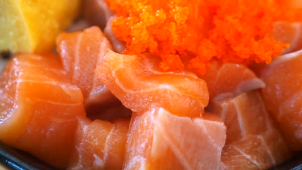 日本料理店で新鮮な魚やキャビアやイクラを使ったサーモンの切り身を閉じます 丼物の新鮮な生鮭の切り身 ご飯の上に生の魚をスライス ヘルシーなおいしい食べ物 — ストック動画