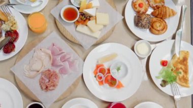 Lüks restoranda kahvaltı ya da öğle yemeği. Masa lezzetli yiyeceklerle dolu. Peynir, somon, jambon, fırın ve meyve suyu. Otelde açık büfe yemeği. Çeşitli atıştırmalıklar ve aperatiflerle sabah yemeği..