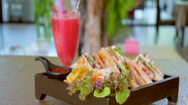 有炸薯条和生菜 烤番茄酱和小食饮料的木制盘子的俱乐部三明治 传统的美式快餐店 好吃的开胃菜 — 图库视频影像