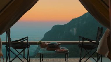Kamp çadırının içinden bak. Dağlarda inanılmaz günbatımı zamanı. Kanyonda iskemlelerin yanında kamp yapmak, BBC yemeklerinin olduğu bir masa. Peyzaj doğa yolculuğu macerası Tayland.