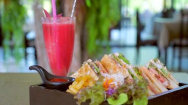 Jambonlu sandviç, peynir, domates, marul ve kafede meyve suyuyla servis edilen kızarmış ekmek. Abur cubur ya da fast food kavramı. Aşırı yemek, sağlıksız yemek..