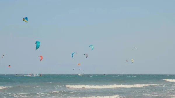Kite boarding. Kitesurfing freestyle at hot sunny day. Active extreme water sport. Kite surfing or windsurfing on blue sea water.