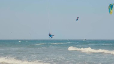 Uçurtma geliyor. Sıcak ve güneşli bir günde serbest uçurtma. Aktif ekstrem su sporu. Uçurtma sörfü ya da mavi deniz suyunda rüzgar sörfü. 