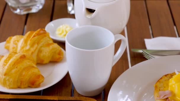 Woman Hand Pouring Tea Teapot Cup Delicious Breakfast Croissants Eggs — Vídeo de stock