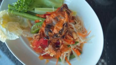Baharatlı yeşil papaya salatası, kızarmış yengeç, yeşil fasulye ve fıstık ile Tayland yemeği konsepti. Tabakta Som tam Thai yemeği. Asya yemekleri. Üst görünüm.