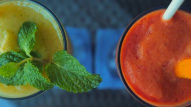 Papaya and mango smoothies with mint leaf on restaurant table. Delicious fruit smoothie viewed from above. Detox smoothies, clean eating, vegetarian or vegan concept.