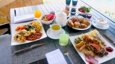 Delicious breakfast spread awaits at this stunning summer vacation destination. Enjoy gourmet buffet near the sea and pool for a truly luxurious experience.