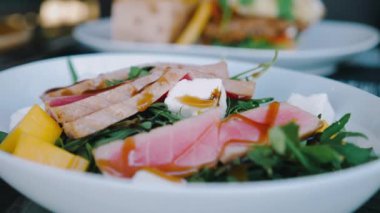 Taze meyve, peynir ve roket salatasıyla kaplı çiğ ton balıklı sashimi salatasıyla taze ve sağlıklı bir restoran yemeği yakın plan. Düşük karbonhidratlı diyetler.