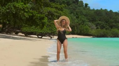 Funny happy woman in swimwear dancing on tropical beach, celebrating summer vacation. Female traveler enjoy perfect holidays, fun, carefree girl.