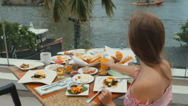 Female Traveler Enjoying Breakfast Drinking Orange Juice View River Sailboats — Vídeo de Stock