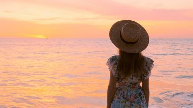 Tayland 'da çarpıcı bir plajda duran kadın turistin yavaş çekimleri. Tatil sezonunda huzurlu bir an. Yaz tropik deniz tatili.