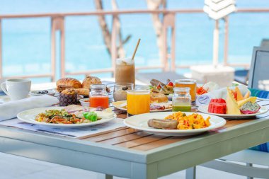 Tropik otellerde deniz manzaralı kahvaltı. Modern tatil köyündeki restoranda açık büfe yemekleri. Seyahat ve yaz tatili kavramı.