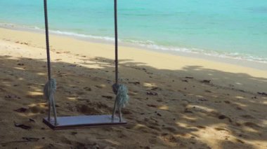 Tropik cennet, boş ahşap salıncak berrak turkuaz deniz manzaralı. Sakin ve huzurlu bir manzara, egzotik adada mükemmel bir yaz tatili..