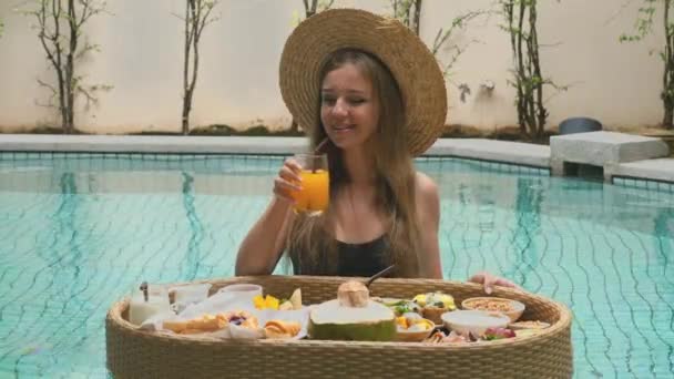 Νεαρή Γυναίκα Απολαμβάνουν Δροσιστικό Ποτήρι Χυμό Πορτοκαλιού Από Πλωτό Δίσκο — Αρχείο Βίντεο