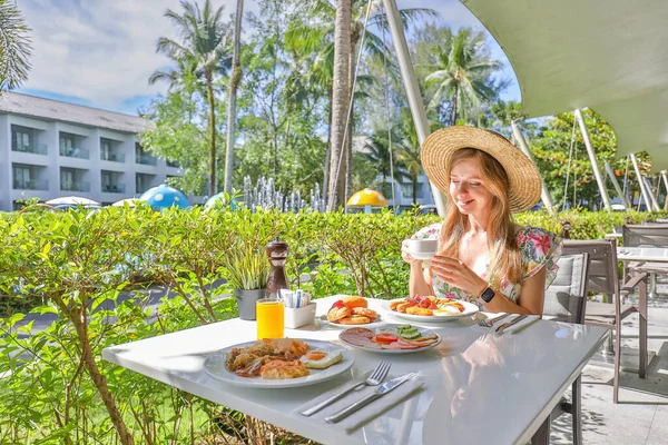 完美的夏日 一个穿着华丽衣服的女人享受户外餐馆的食物 旅途愉快 在泰国度假 享受暑假 慢动作 免版税图库照片