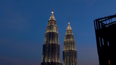 Kuala Lumpur Petronas Kuleleri gün batımında gökdelenden izlenen gökyüzünde dimdik ayakta duruyor. İkiz ikiz kuleler, başkentin modern mimari simgesidir. Kuala Lumpur, Malezya, Ağustos 2022