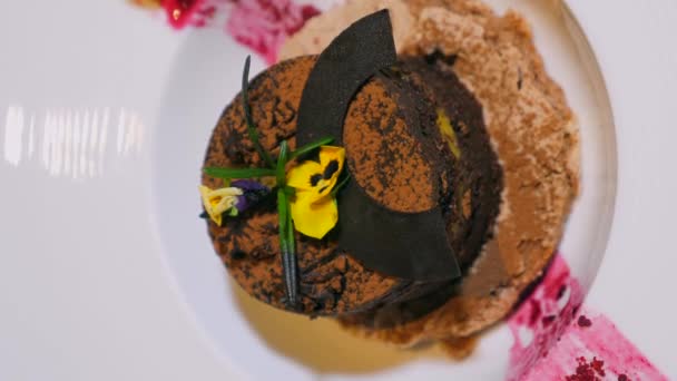 Вертикальне Відео Смачного Шоколадного Торта Малиновим Джемом Прикрашеним Їстівними Квітами — стокове відео