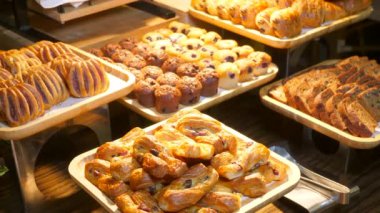 Otel kahvaltı büfesinde lezzetli kruvasanlar, çörekler ve çörekler. Çeşitli taze hamur işleri ve fırın ürünleri. Tepside lezzetli yiyeceklerin yakın çekimi..