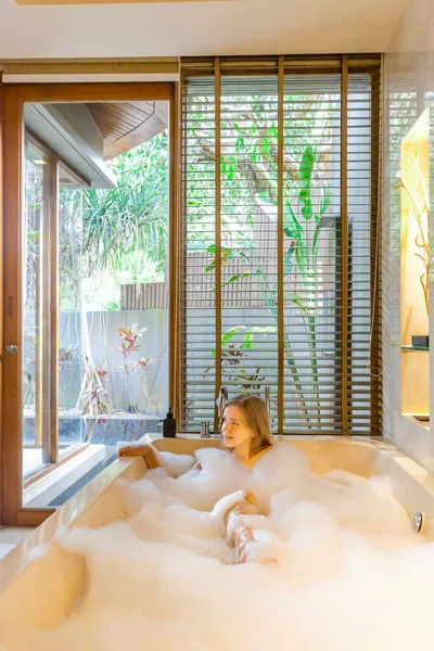 在奢华的热带别墅里 一个漂亮的裸体女人正在一个现代化的浴室里 在一个充满泡沫的浴缸里享受着放松的浸泡 温泉和放松 美容美发 度假概念 — 图库照片