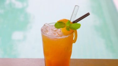 Nane yaprağı ve buzla ferahlatıcı portakal suyu yakın, havuz başında yaz tatili için mükemmel. Lüks kaplıcalarda sağlıklı ve meyveli içeceklerin tadını çıkarın..