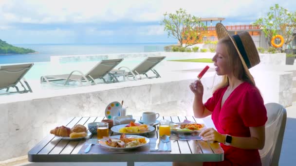 방학중인 밀짚모자를 여급은 호텔에서 해수욕장에서 식사로 과일을 즐긴다 식탁에 관광객 — 비디오
