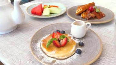 Lezzetli tatlı yiyecekler. Kahve masasında taze krep, böğürtlen, waffle ve meyveli. Şeker, sağlıksız gıda konsepti.