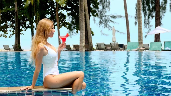 여성은 럭셔리 리조트에서 알코올 칵테일을 마시며 수영장에서 즐거운 시간을 보내고 — 스톡 사진